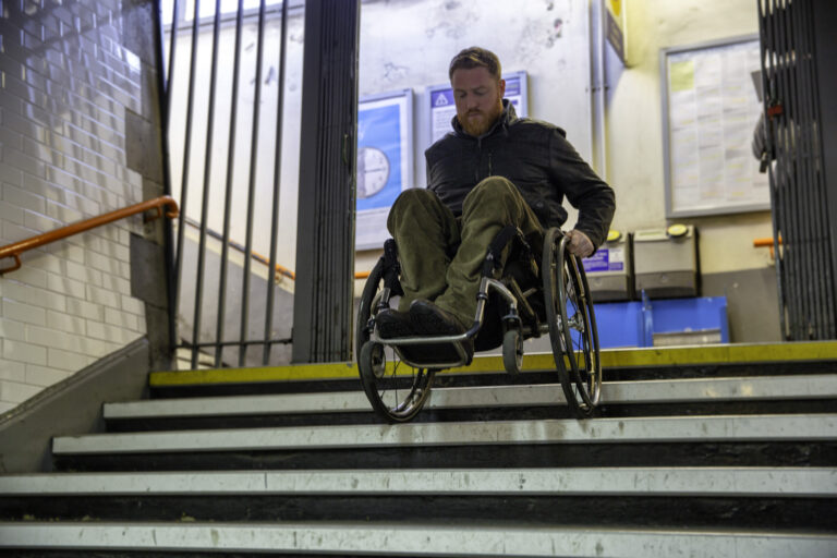 Manual wheelchair user going downstairs forwards in wheelchair